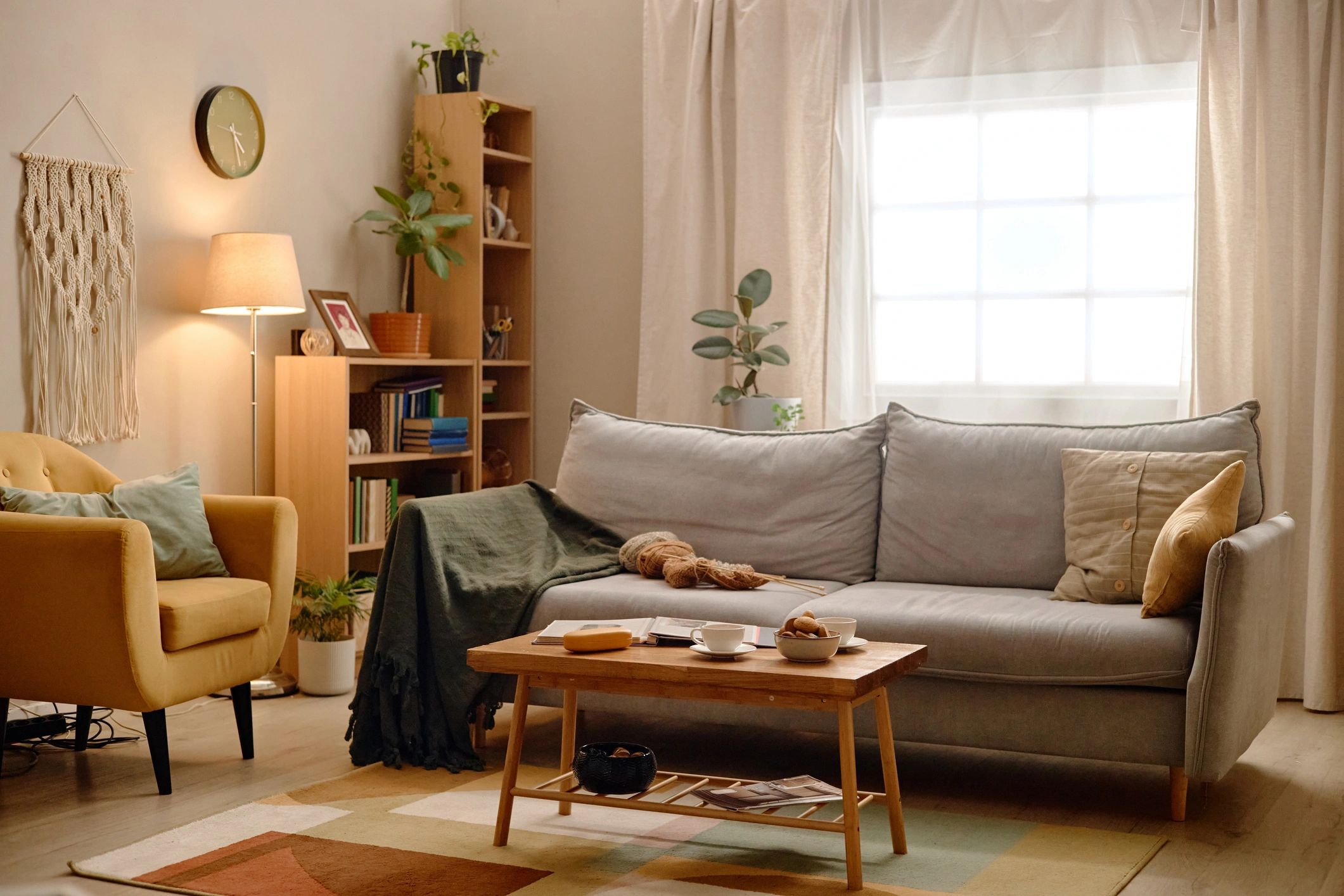 Warm living room with full length linen curtains, sofa and armchair